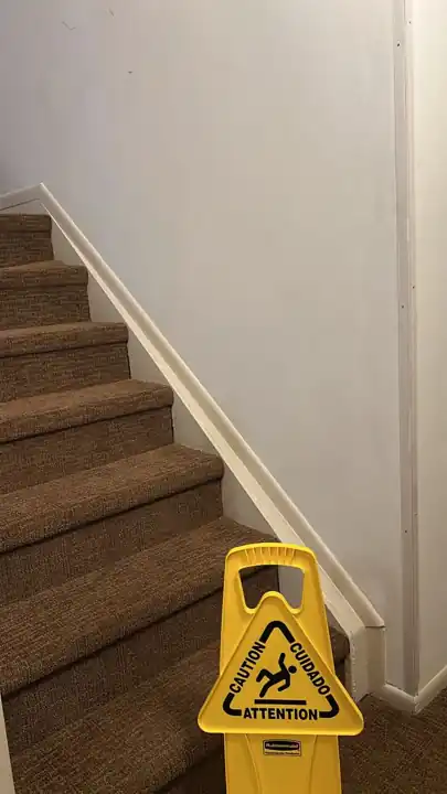 Finished stairwell with clean walls and our wet floor caution sign